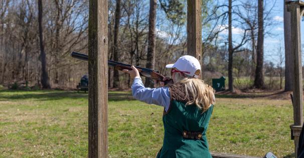 Female shooting shotgun on Turcotte Shooting Facility's Sporting Clay Course